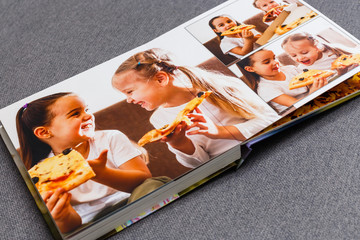 children's photo book, children eat pizza - obrazy, fototapety, plakaty