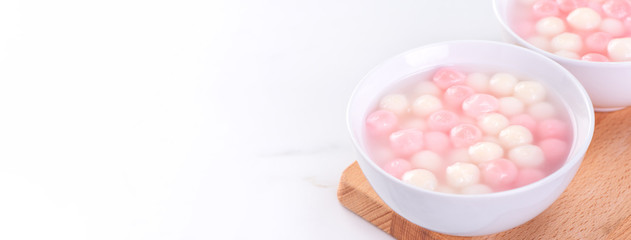 Tang yuan, tangyuan, delicious red and white rice dumpling balls in a small bowl. Asian traditional festive food for Chinese Winter Solstice Festival, close up.