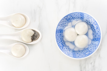 Tang yuan, tangyuan, yuanxiao in a small bowl stuffed with sesame fillings, top view, flat lay. Delicious asian food rice dumpling balls for festival.