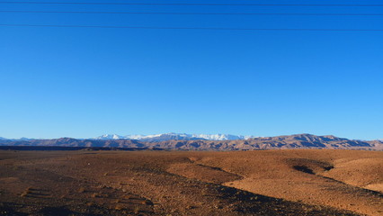 Fototapeta premium Bright landscape of Morocco, breathtaking curves of mountains, stunning combination of hills & farm land,inadvertent distribution of houses & huts, raw impression of pure nature.