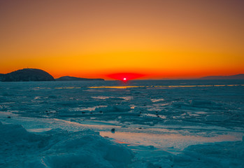 Seascape with sunset view over the icy surface.