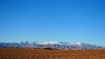 Bright landscape of Morocco, breathtaking curves of mountains, stunning combination of hills & farm land,inadvertent distribution of houses & huts, raw impression of pure nature.