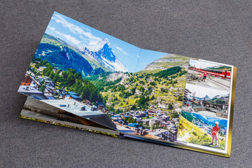 Fototapeta na wymiar the photobook opened, travel in switzerland, on gray background