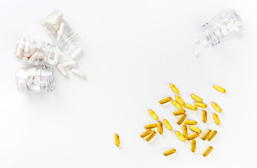 Four packages with various white pills and golden tablets on a white background. Health concept. Top view with copy space.