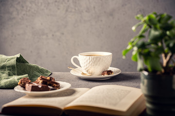 Coffee break composition with cup of coffee and chocolate. Healthy breakfast concept with copy space. Toned photo