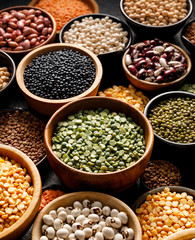 Legumes, a set consisting of different types of beans, lentils and peas on a black background, close up. The concept of healthy and nutritious food