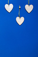 Wooden hearts on classic blue background. Valentine's Day Greeting Card.