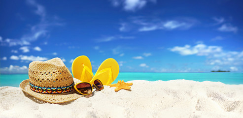 Concept summer beach holiday. Beach accessories - straw hat, glasses, starfish, yellow flip-flops...