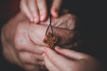 church cross in the hands of a child and grandmother
