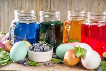 Easter organic and zero waste concept. Easter eggs painted with natural egg dye, fruits and vegetables. Wooden background