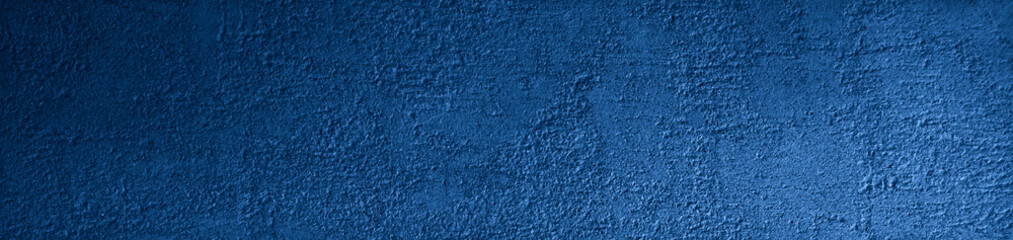 Blue grunge background. Texture of the rough surface of a concrete wall. Blue grunge banner with copy space for your design.