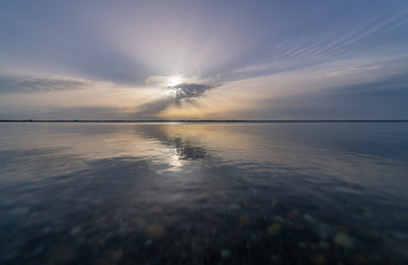 sunset with rays breaking through the clouds on proud in Canet-en-Roussillon