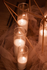 burning candles in a glass candlestick with tulle. decoration for a wedding or a cozy evening