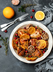 Baked chicken legs with garlic, orange and cranberry. Spicy bbq chicken legs