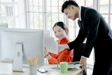 Two young business people analyzing graphs during