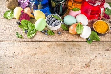Easter organic and zero waste concept. Easter eggs painted with natural egg dye, fruits and vegetables. Wooden background