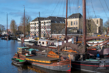 Historical inhabited sailing ships in the Museum harbor of Gouda, the laundry is hanging on the clothesline to dry.