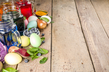 Easter organic and zero waste concept. Easter eggs painted with natural egg dye, fruits and vegetables. Wooden background