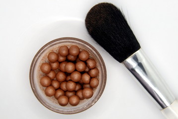 makeup brush and ball powder on a white background