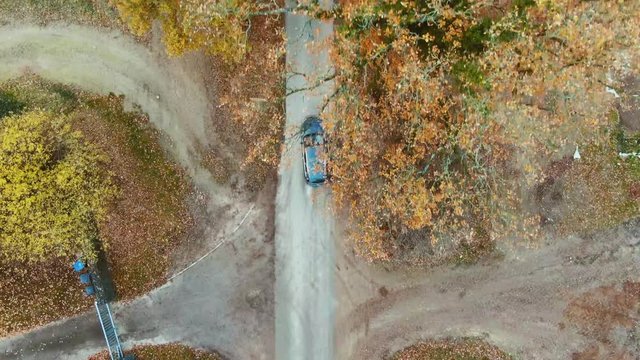 Luftaufnahme Auto fährt auf Landstraße im Herbst Top View
