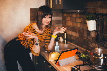 Girl cook using online recipe on tablet on kitchen
