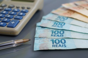 Brazilian Real banknotes, calculator and pen. Economy, savings and business concept. Brazilian money,
