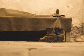 a pair of boots beside a bed
