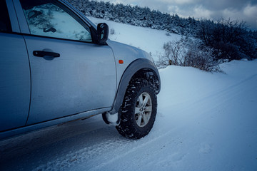 Pickup truck on road, Beautiful winter road under snow mountains. © Seleznov_Molchanova