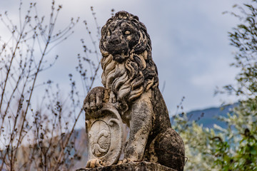 Puget-Theniers, France - January 23, 2020: A statue of a lion holding the 'fleur-de-lis' emblem...