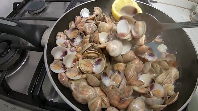  The clams open and cook with lemon, oil and their sauce. Seafood caught in the Mediterranean sea