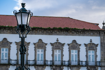 Fototapeta na wymiar Selective focus on an ornate street lamp with traditonal Portugal building blurred in background at sunset in Porto, Portugal