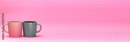 Two beautiful cups of pink and gray are on a pink background. The concept of the holiday is Valentine's Day, Mother's Day, International Women's Day. Place for text. Minimalism with coffee. Breakfast