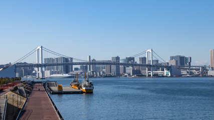 青空を背景に豊洲ふ頭から見たレインボーブリッジと東京湾岸のビル群