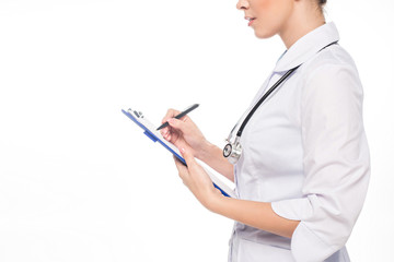 Cropped view of doctor with stethoscope writing on clipboard isolated on white