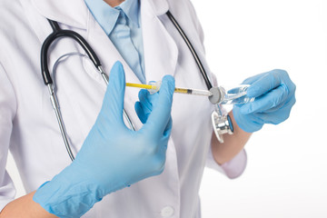 Cropped view of female doctor in white coat picking up vaccine in syringe isolated on white