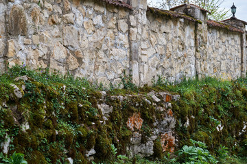 Old stone fence overgrown with moss