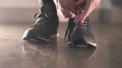 Jogger tying sneaker shoelaces before running