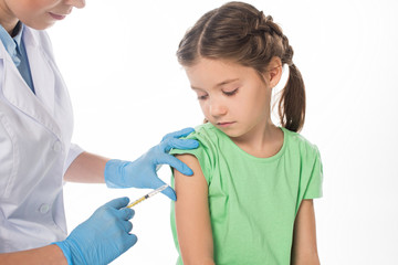Female pediatrician doing vaccine injection to child isolated on white