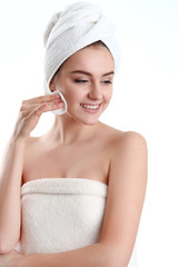 close-up of beautiful young woman with bath towel on head covering her breasts, on white