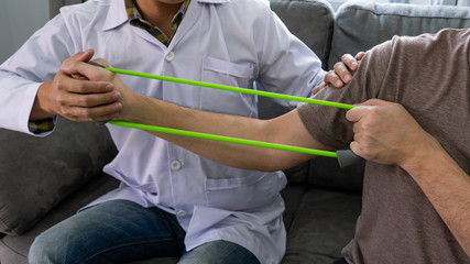 instructor assisting senior doing exercise working out in clinic strengthening muscles and developing joints.