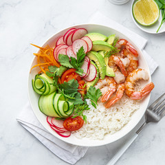 Avocado, shrimps, cucumber, tomato, radish, carrot and rice salad bowl. Healthy food.