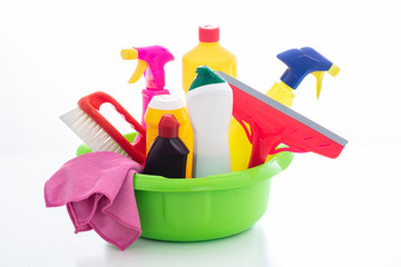 Cleaning supplies in a green bowl isolated against white background.