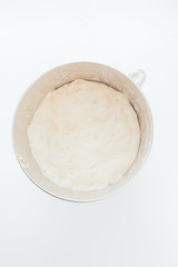 Baking cereal bread a Step by step guide to bake cereal bread,  top view on a white board, dough is prepared mixing all ingredients and left rising on a metalic bowl