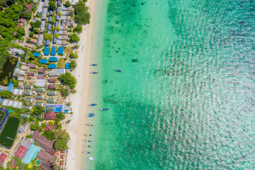 Blue clear water with boats. Green tropical island Phi Phi, palm trees grow. Shooting from a drone...