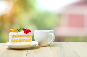 Slice cake with coffee cup on wood , green blur background