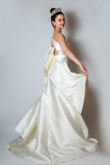 Fototapeta na wymiar Beautiful young bride in white wedding dress indoors. beauty emotional brunette bride in luxury dress