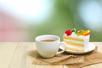 Slice cake with coffee cup on wood , green blur background