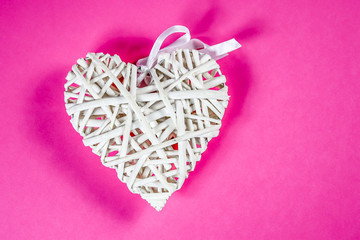 coeur en bois sur un fond rose