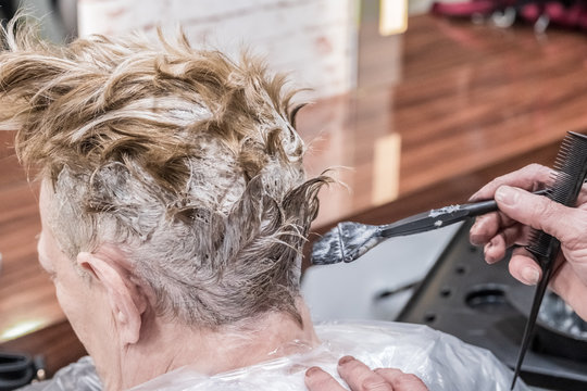 Professional Hairdresser Dying Client's Hair In Beauty Salon