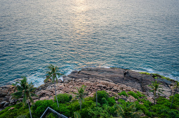 Beautiful view of waves splashing on the rocky beach during sunset. From Vizhinjam Beach, Thiruvananthapuram, Kerala, India. Aerial Shot.